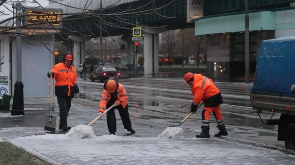 Работники коммунальных служб убирают улицу в Южном Бутово в Москве после прошедшего ледяного дождя