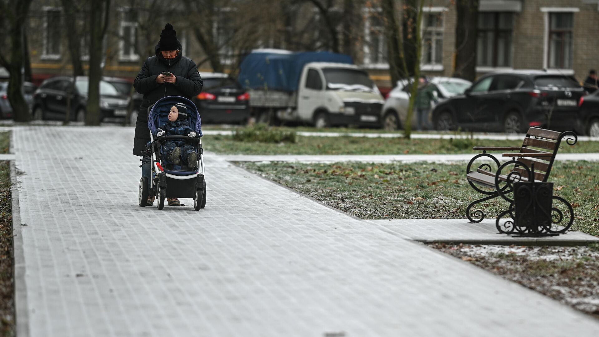 Женщина с коляской идет по обледеневшему тротуару на одной из улиц в Москве - РИА Новости, 1920, 26.02.2021