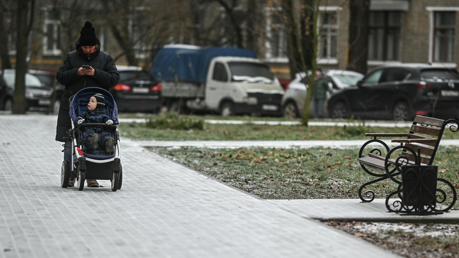 Женщина с коляской идет по обледеневшему тротуару на одной из улиц в Москве - РИА Новости, 1920, 26.02.2021