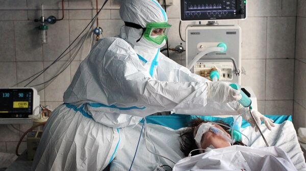 Медицинский работник и пациент в отделении интенсивной терапии ковид-госпиталя в городе Новоалтайске