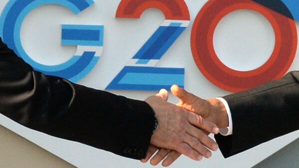 Рукопожатие на фоне логотипа Большой Двадцатки