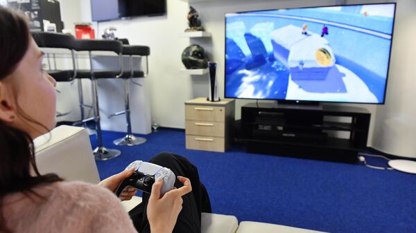 Девушка тестирует новую игровую приставку Sony PlayStation 5 в магазине в Москве