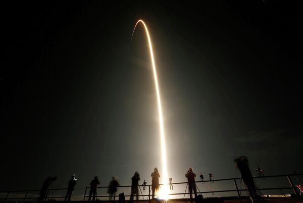 Люди наблюдают за пуском ракеты SpaceX Falcon 9 с капсулой Crew Dragon