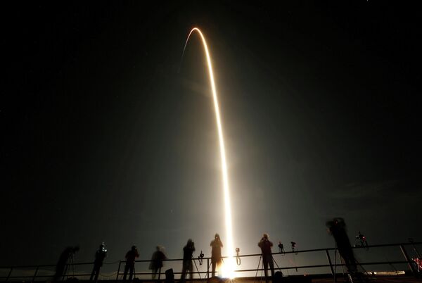 Люди наблюдают за пуском ракеты SpaceX Falcon 9 с капсулой Crew Dragon Люди наблюдают за пуском ракеты SpaceX Falcon 9 с капсулой Crew Dragon