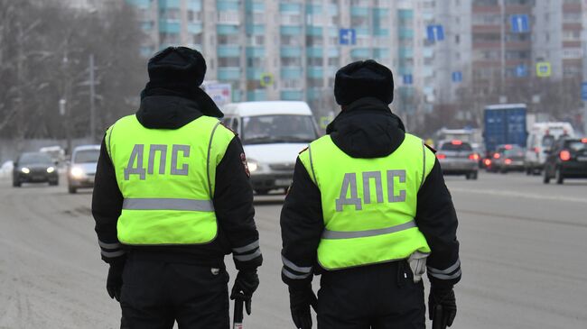 Сотрудники ДПС ГИБДД во время проверки соблюдения масочного режима водителями такси в Новосибирске