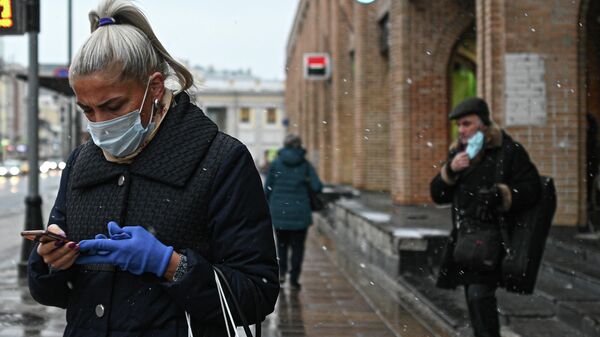 Женщина в защитной маске на улице в Москве