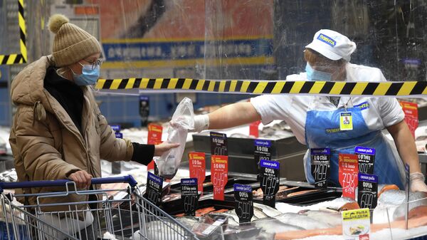 Покупатель и продавец в рыбном отделе гипермаркета Лента в период пандемии коронавируса в Новосибирске