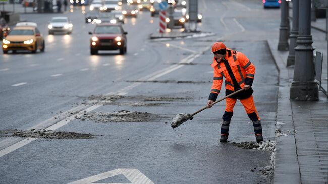 Сотрудник коммунальных служб во время уборки снега в Москве