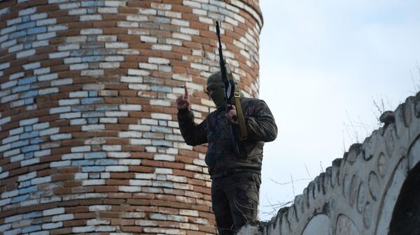 Вооруженный мужчина на крыше мечети Джума в Агдаме