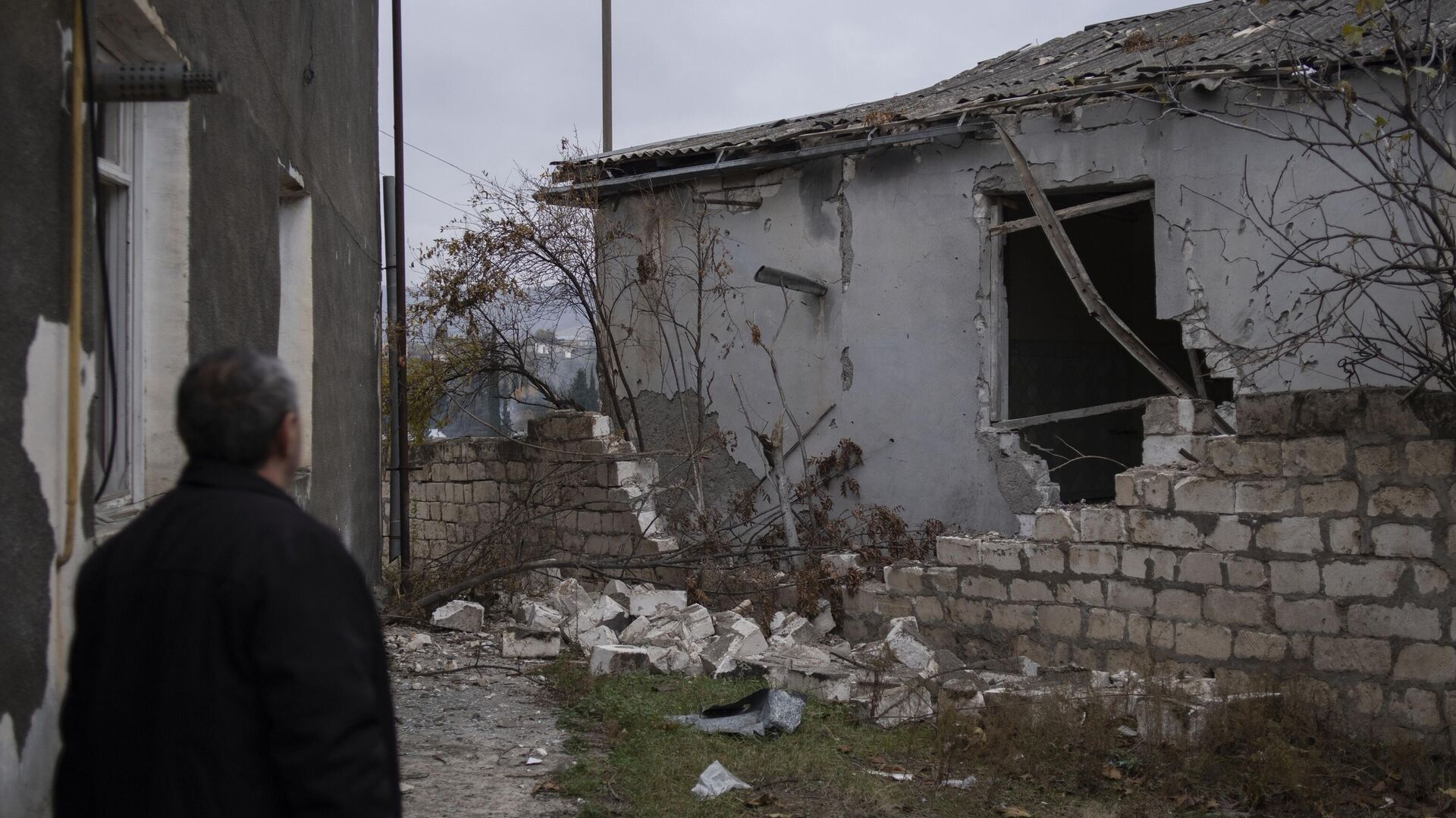 Мужчина возле частично разрушенного дома в Мартакерте - РИА Новости, 1920, 13.04.2022