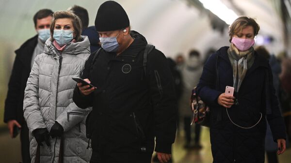 Пассажиры в защитных масках на одной из станций Московского метрополитена