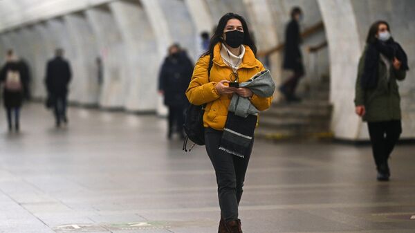 Девушка в защитной маске на одной из станций Московского метрополитена