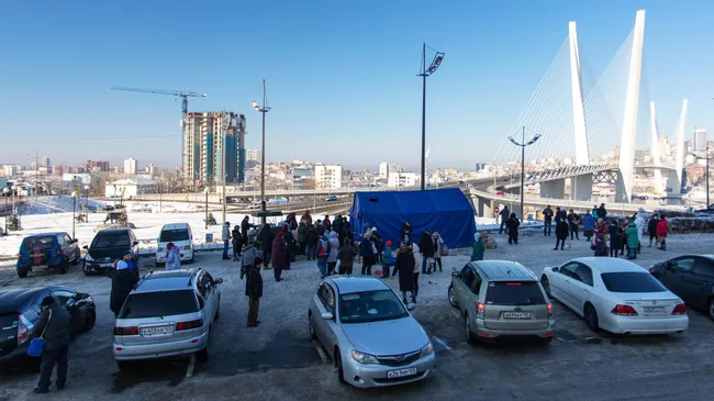 Местные жители стоят в очереди возле полевой кухни во Владивостоке