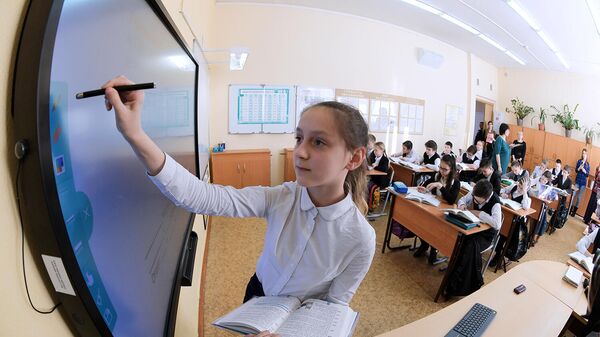 Ученица выполняет задание возле интерактивной доски
