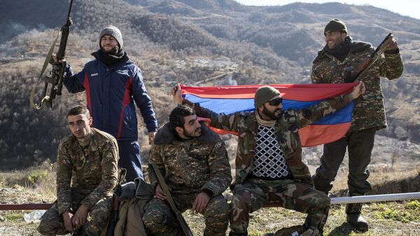 Вооруженные мужчины с флагом Армении в Кельбаджарском районе Нагорного Карабаха накануне передачи Азербайджану