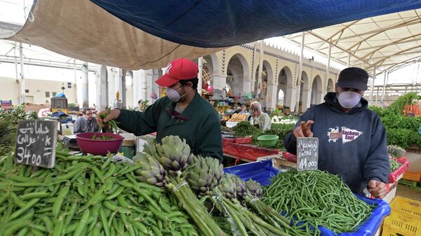 Продавцы в защитных масках на центральном рынке в Тунисе