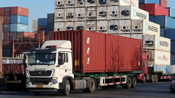 Грузовик с контейнером в логистическом центре недалеко от порта Тяньцзинь в Китае
