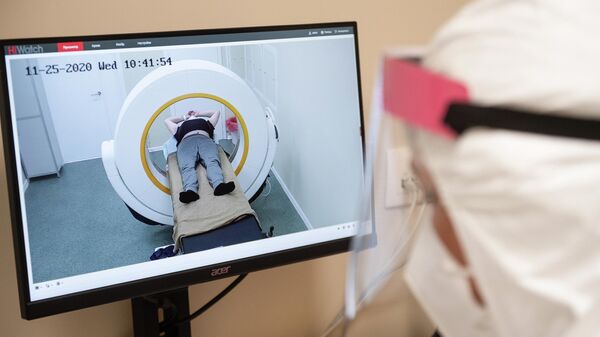 Врач проводит обследование пациента на аппарате компьютерной томографии во временном госпитале для пациентов с COVID-19, развернутом в ледовом дворце Крылатское
