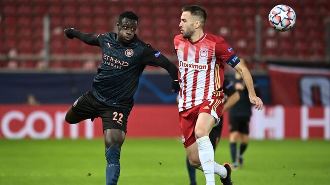 Manchester City's French defender Benjamin Mendy (L) fights for the ball with Olympiakos' Greek midfielder Kostas Fortounis during the UEFA Champions League group stage football match between Olympiakos and Manchester City, on November 25, 2020 at Georgios-Karaiskakis stadium in Piraeus, near Athens. (Photo by ARIS MESSINIS / AFP)