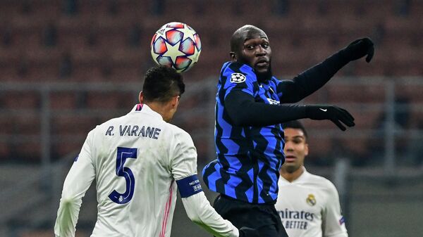 Real Madrid's French defender Raphael Varane (L) and Inter Milan's Belgian forward Romelu Lukaku go for a header during the UEFA Champions League Group B football match Inter Milan vs Real Madrid on November 25, 2020 at the Giuseppe-Meazza (San Siro) stadium in Milan. (Photo by MIGUEL MEDINA / AFP)