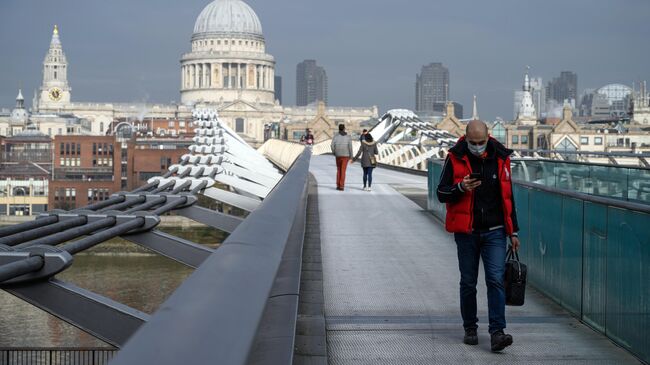 Прохожие на мосту Тысячелетия в Лондоне во время карантина, введенного в связи с коронавирусом