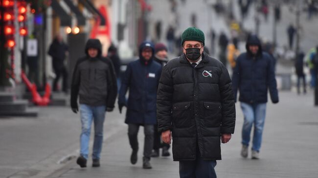 Прохожие в защитных масках на улице в Москве