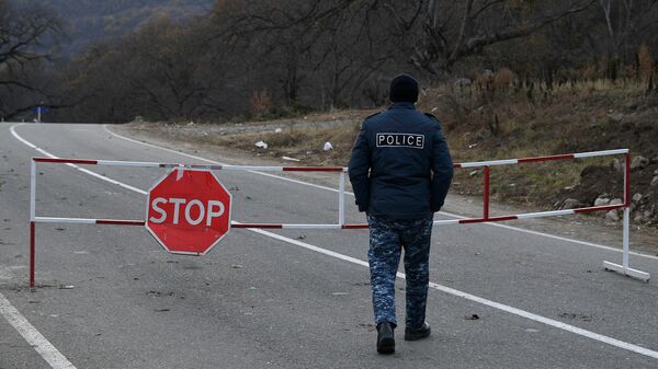 Полицейский возле контрольно-пропускного пункта на автомобильной дороге Варденис-Мартуни у населенного пункта Гетаван, Азербайджан