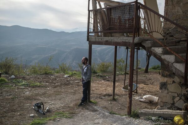 Мужчина возле дома в поселке Карегах в Нагорном Карабахе