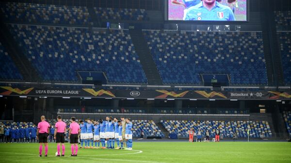 A screen displays a photo of late Argentinian football legend Diego Maradona as players hold a minute of silence in homage to Maradona prior to the UEFA Europe League Group F football match Napoli vs Rijeka on November 26, 2020 at the San Paolo stadium in Naples. - Maradona, widely remembered for his Hand of God goal against England in the 1986 World Cup quarter-finals, died on November 25, 2020 of a heart attack at his home near Buenos Aires in Argentina, while recovering from surgery to remove a blood clot on his brain. (Photo by Filippo MONTEFORTE / AFP)