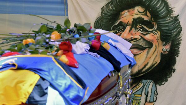 EDITORS NOTE: Graphic content / Handout photo released by Argentina's Presidency of fans paying tribute to the coffin of Argentine football legend Diego Maradona at the burning chapel in Casa Rosada presidential palace in Buenos Aires on November 26, 2020. - Diego Maradona will be buried Thursday on the outskirts of Buenos Aires, a spokesman said. Maradona, who died of a heart attack Wednesday at the age of 60, will be laid to rest in the Jardin de Paz cemetery, where his parents were also buried, Sebastian Sanchi told AFP. (Photo by - / Argentinian Presidency / AFP) / RESTRICTED TO EDITORIAL USE - MANDATORY CREDIT AFP PHOTO / ARGENTINIAN PRESIDENCY - NO MARKETING NO ADVERTISING CAMPAIGNS -DISTRIBUTED AS A SERVICE TO CLIENTS
