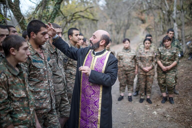 Иерей Аристакес Оганнисян проводит обряд крещения военнослужащих недалеко от передовой линии Иерей Аристакес Оганнисян проводит обряд крещения военнослужащих недалеко от передовой линии