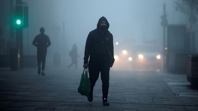 Пешеход в защитной маске на улице в районе Уолтамстоу в Лондоне