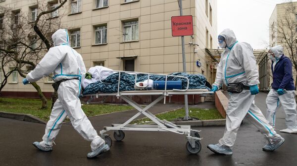 Медицинские работники транспортируют пациента в красную зону госпиталя COVID-19 в городской клинической больнице № 52 в Москве