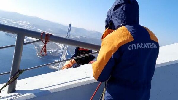 Альпинисты МЧС вручную чистят мост на остров Русский от наледи