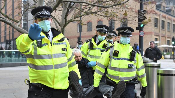 Полиция задерживает протестующего против мер по борьбе с коронавирусом у Кингс-Кросс-Сент-Панкрас в Лондоне