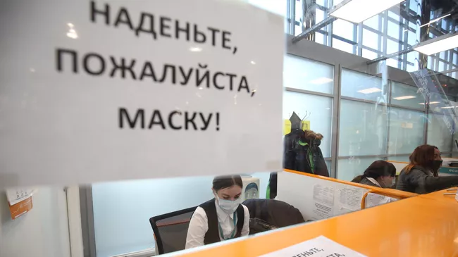 Предупреждение о необходимости надеть маску, наклеенное на стойку регистрации в международном аэропорту Волгограда