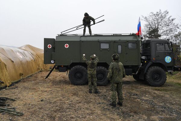 Российские военнослужащие выгружают оборудование на территории мобильного полевого госпиталя неподалеку от Степанакерта