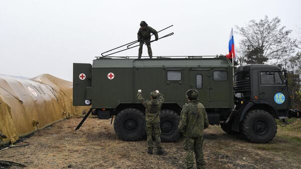 Российские военнослужащие выгружают оборудование на территории мобильного полевого госпиталя неподалеку от Степанакерта