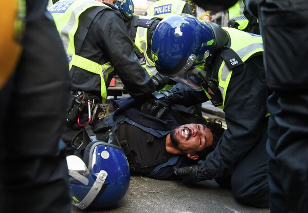 Полиция задерживает участника протеста против ограничительных мер, введённых из-за пандемии коронавируса, в Лондоне