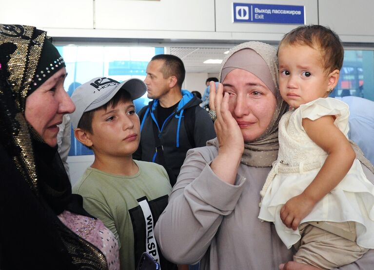 Девочка на руках у своей тети Разет во время встречи в аэропорту Грозного
