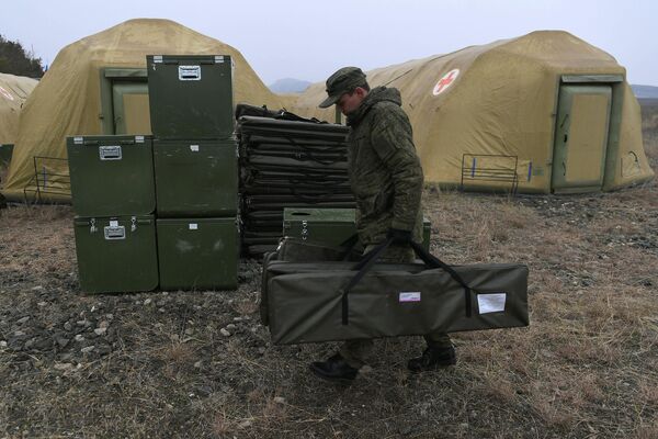 Российский военнослужащий выгружает оборудование на территории мобильного полевого госпиталя неподалеку от Степанакерта