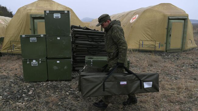 Российский военнослужащий выгружает оборудование на территории мобильного полевого госпиталя неподалеку от Степанакерта