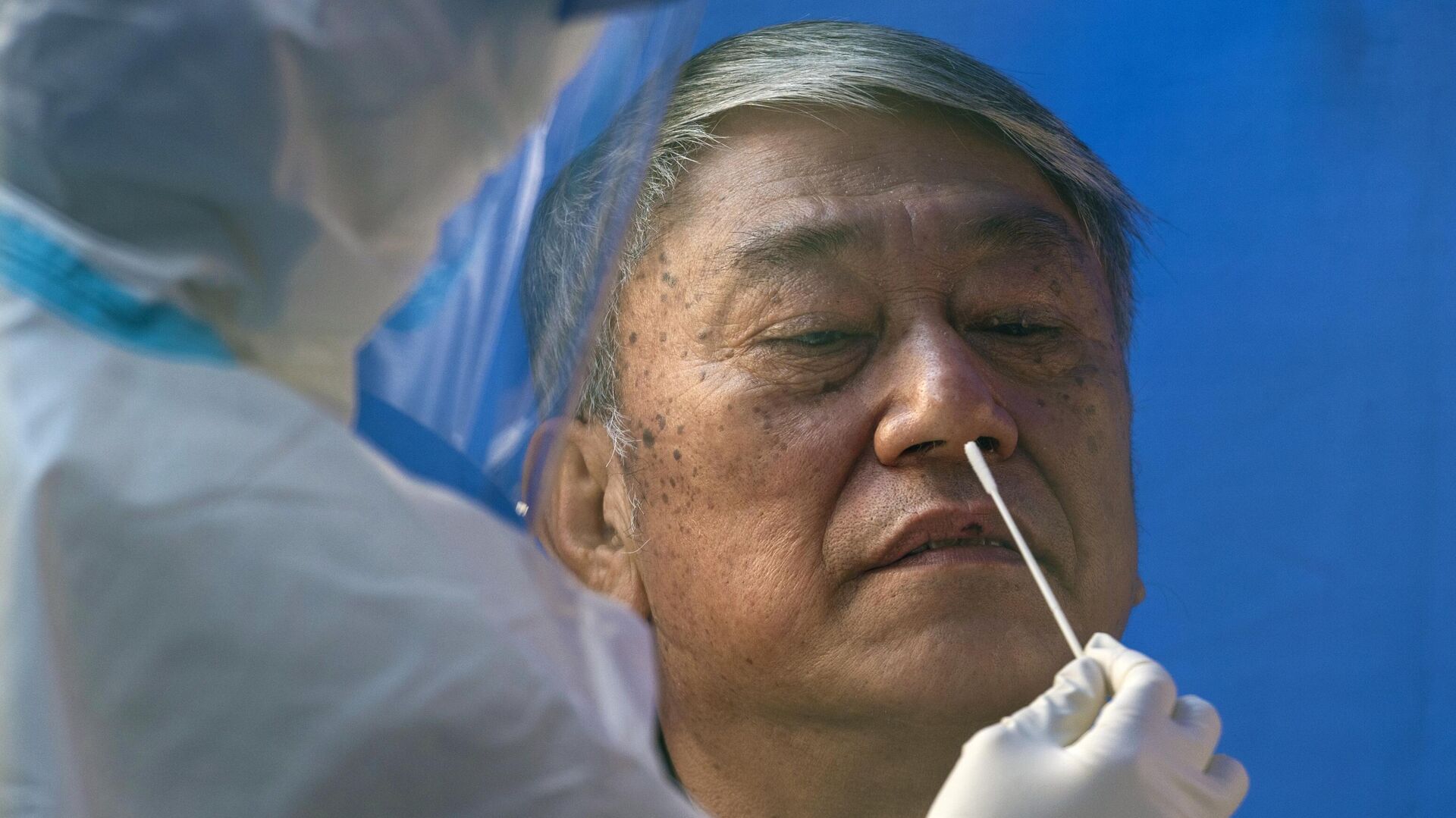 Мужчина проходит тестирование на коронавирус в общественном центре тестирования в Гонконге - РИА Новости, 1920, 02.12.2021