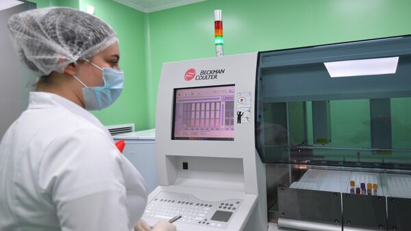 Лаборант Научного Центра по профилактике и борьбе со СПИДом в Москве проводит исследование крови на ВИЧ-инфекцию