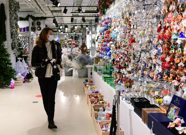 Продажа елочных игрушек и новогодних украшений на новогоднем базаре в ЦУМе в Москве