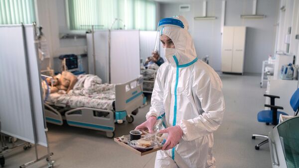 Медицинский работник и пациент в отделении реанимации и интенсивной терапии в госпитале для больных COVID-19 в  Московском клиническом центре инфекционных болезней Вороновское