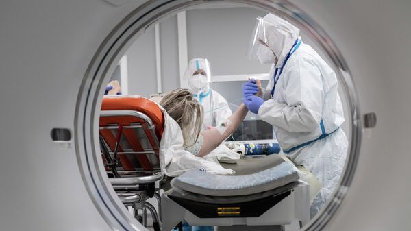 Медицинские работники и пациент в кабинете компьютерной томографии госпиталя для больных COVID-19 в  Московском клиническом центре инфекционных болезней Вороновское
