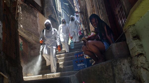Волонтеры распыляют дезинфицирующее средство в трущобах Санта-Марта в Рио-де-Жанейро, Бразилия