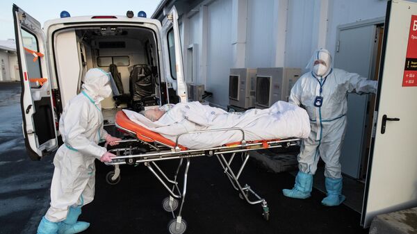 Медицинские работники во время транспортировки пациентки в госпитале для больных COVID-19 в МКЦИБ Вороновское
