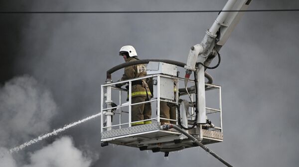 Сотрудник пожарной службы МЧС РФ во время тушения пожара